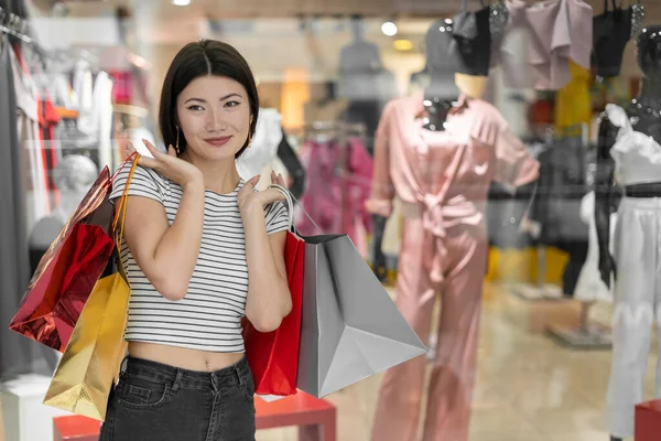 妇女服装店 年轻美丽的韩国女人手里拿着纸袋站在商店橱窗边 黑色星期五 — 图库照片