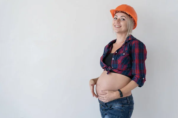 Беременная Женщина Стоит Белом Фоне Рабочей Одежде Оранжевый Строительный Шлем — стоковое фото