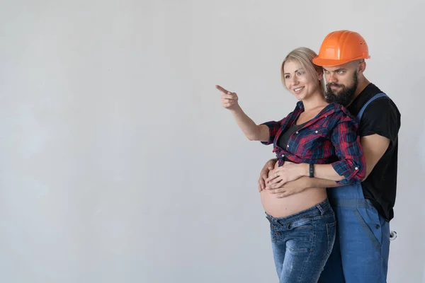 Bir Erkek Hamile Karısına Sarılır Üniforması Turuncu Güvenlik Kaskı Kadın — Stok fotoğraf