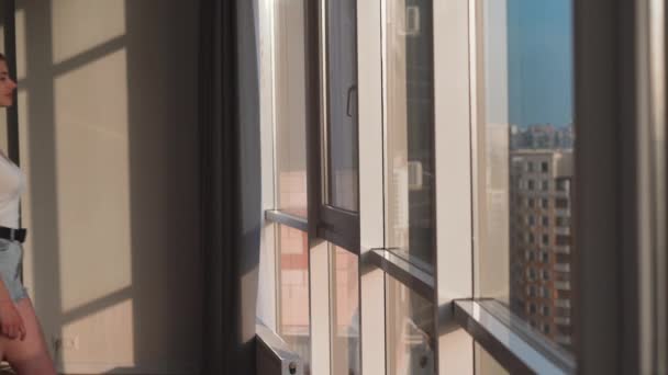 Ung vacker kvinna med mörkt hår öppnar fönstret i hotellrummet. — Stockvideo