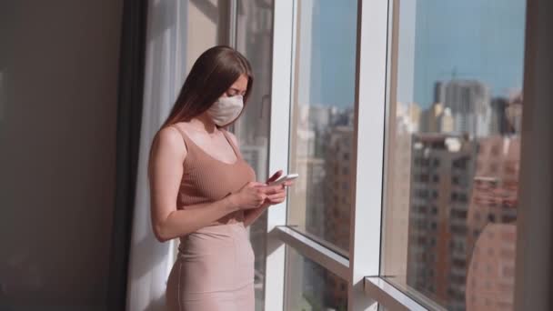 Молода Красива Жінка Медичній Масці Обличчі Стоїть Біля Великого Вікна — стокове відео