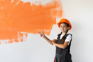 Tulum giymiş turuncu boyalı çekici bir kızın portresi. Duvarın arka planında leke var. Metin için boş bir yeri işaret etmek çocukluk kavramı, yetişkinlere yardım, yeniden yapılanma..