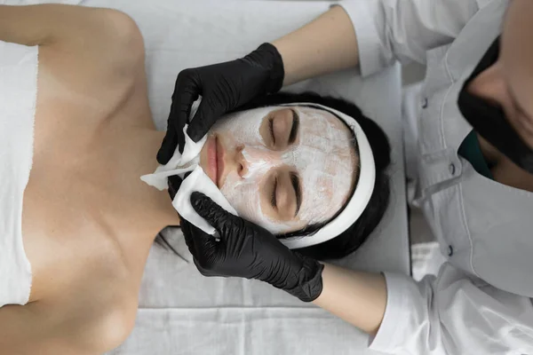 Esteticista Limpia Máscara Cara Paciente Joven Con Almohadillas Algodón Salón — Foto de Stock