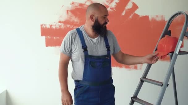 Stavitel Uniformě Oranžové Ochranné Přilbě Vousatý Muž Vezme Helmu Nasadí — Stock video