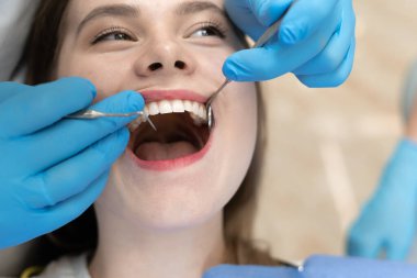 Kadın çenesi, yakın plan. Diş hekiminin elinde aletlerle. Taşıma tedavisi kavramı