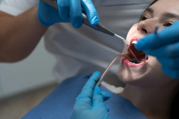 Dentist treating female patient. Healthy teeth concept.