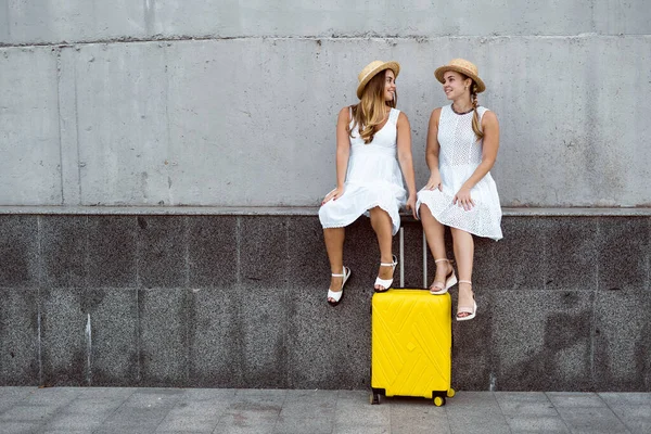 Beautiful Two Female Tourist Twins Sitting Large Yellow Suitcase Smiling — Stock Photo, Image