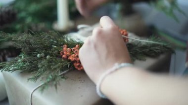 Tatiller, yeni yıl ve noel konsepti - kadın elleri bir kutuyu hediyeyle süsler