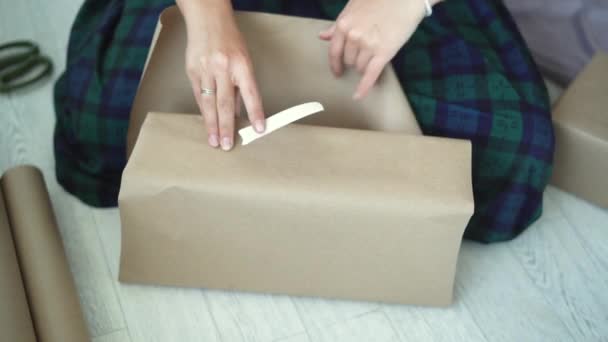 Holidays, new year and christmas concept - close-up of female hands are packing a gift — Stock Video