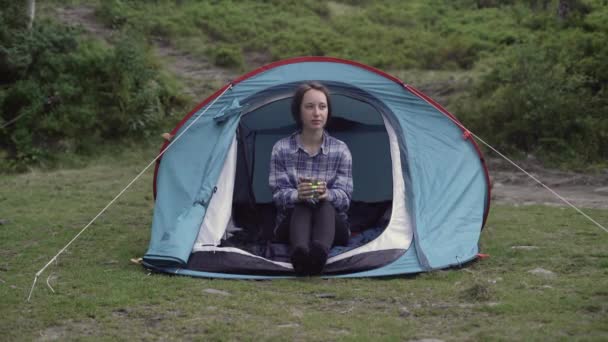 Ung smuk pige af europæisk udseende sidder i et telt drikker te – Stock-video