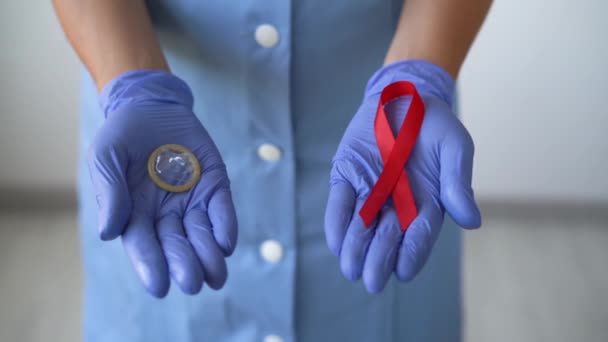 Närbild av kvinnliga händer i medicinska handskar i en kondom i en annan byråkrati. Aids-dagen — Stockvideo