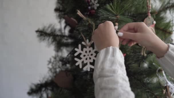 Närbild av kvinnliga händer hänga en ängel leksak på julgranen — Stockvideo
