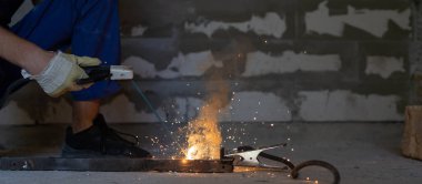 Kaynakçı metal ve kıvılcımlar üretir, yakın çekim eller. Boşluğu kopyala.