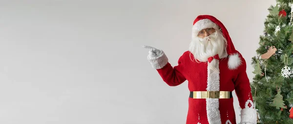 Kerstman Staat Naast Kerstboom Met Zijn Wijsvinger Wijzend Naar Lege — Stockfoto
