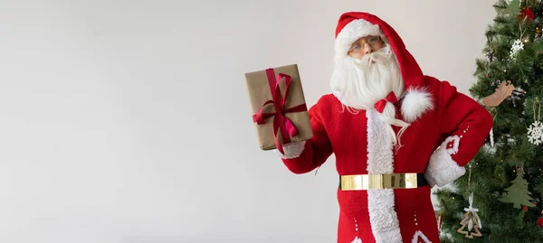 Kerstman Staat Naast Kerstboom Met Een Doos Met Een Geschenk — Stockfoto