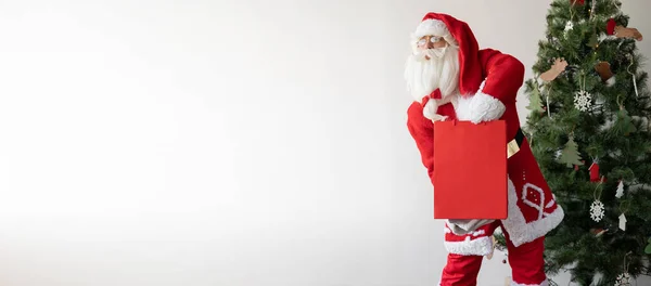 Kerstman Staat Bij Kerstboom Met Een Grote Papieren Zak Neemt — Stockfoto