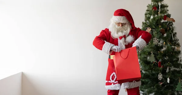 Noel Baba Noel Ağacının Yanında Duruyor Elinde Bir Alışveriş Çantası — Stok fotoğraf