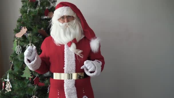 Noel Baba Noel ağacının yanında işaret parmağını sallıyor. Çocuk yorumu konsepti — Stok video