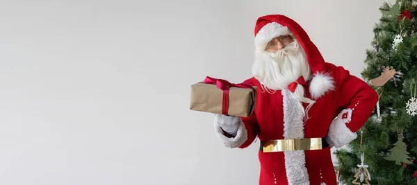 Kerstman Staat Naast Kerstboom Met Een Doos Met Een Geschenk — Stockfoto