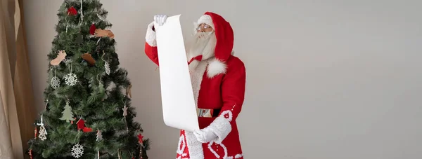 Santa Claus Stojí Vánočního Stromku Rukou Drží List Papíru Koncept — Stock fotografie