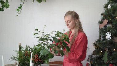 Tulum giymiş kadın çiçekçi odayı dekore ediyor. Noel hazırlığı konsepti