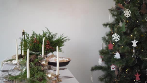 Liten flicka hjälper till att dekorera bordet för en festlig julmiddag. Tar och lägger en tallrik på bordet — Stockvideo
