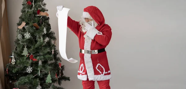 Santa Claus Červeném Obleku Stojí Vánočního Stromku Pozor Velký Seznam — Stock fotografie