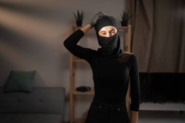 Siyah kar maskeli kadın hırsız yeni bir fikir düşünerek kafasını kaşıyor. Hırsızlık, soygun ve hırsızlık konsepti