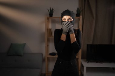 Yüz ifadesi. Siyah kar maskeli kadın hırsız omg ile, heyecandan şok olmuş, kameraya bakıyor. kopyalama alanı. Suç, soygun, hırsızlık ve hırsızlık kavramı