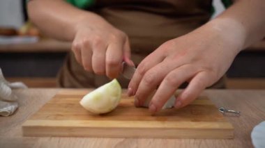 Kadın aşçı kesim tahtasında soğan doğruyor. Sağlıklı vejetaryen yemekleri pişirme süreci. yakın plan