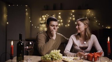 Romantik genç çift mutfakta akşam yemeği yiyor Sevgililer Günü kutlamalarında birlikte eğleniyorlar. Boşluğu kopyala