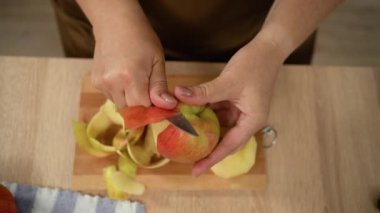 Kadın ellerine yakın çekim Elma soyma, üst manzara