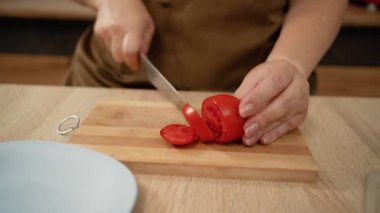 Kadın, mutfak için domatesleri doğruyor. yakın plan