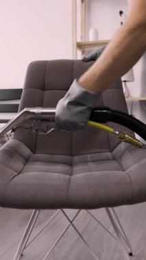 Düzenli temizlik. Kuru temizlemeci çalışanı elektrikli süpürge kullanarak özel bir sıvıyla kirli bir çayı temizliyor. Temizlik şirketi konsepti. yakın plan