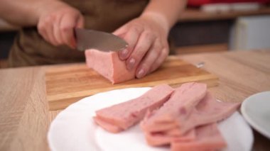 Ahşap tahtada haşlanmış jambon dilimlenmiş bir kadın. Şef kahvaltı hazırlıyor. yakın plan