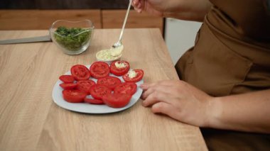 Domates dilimleri sarımsaklı mayonez sosuyla yayılır. Sebze aperatifi. Yakın plan.