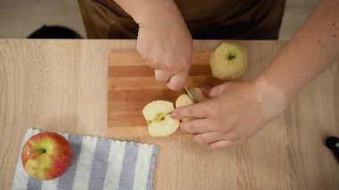 Kadın elmalı turta pişirirken bıçakla elma kesiyor. Elma diyeti ve vitaminler. Yakın plan. en üstteki görünüm