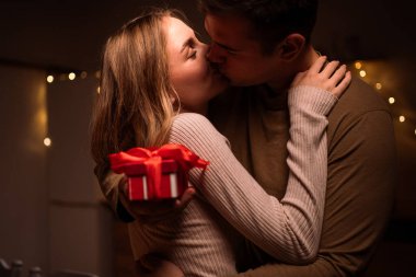 Yıldönümünü mü yoksa evde Sevgililer Günü 'nü mü kutluyoruz? Mutfakta bir çift öpüşüyor, erkek sevgilisine hediye paketi veriyor kadın da ona sarılıyor. Romantik konsept