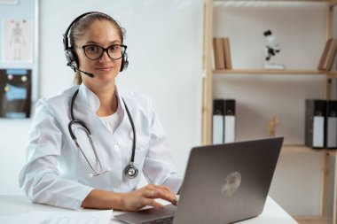 Kadın doktor ya da terapist, internetten danışmanlık yapan bir hastayla konuşuyor. Teletıp konsepti. Boşluğu kopyala