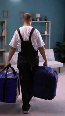 Dry cleaning worker preparing vacuum cleaner to removing dirt from sofa at home. vertical video