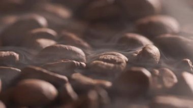 Black coffee beans with steam. texture of coffee beans. food backgoround