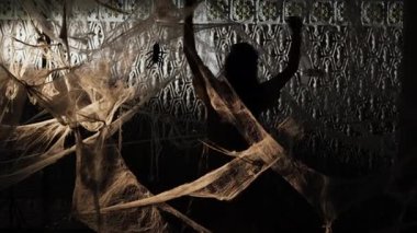 Woman dancing in dark room with spiderwebs at night. dancing, talent, artistic expression and traditional choreography. copy space