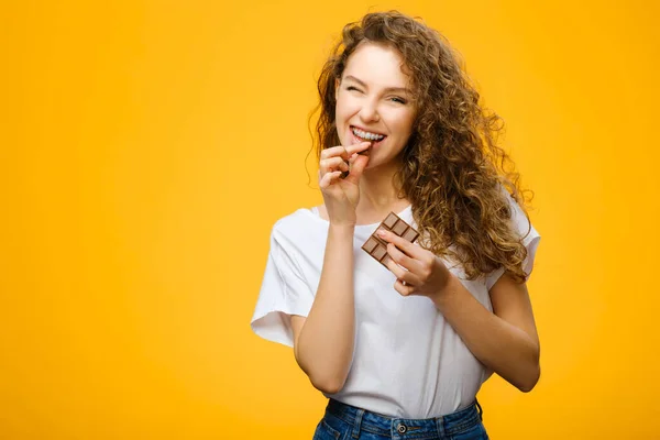 Pretty Girl Takes Bite Milk Chocolate Isolated Yellow Background Studio — Stock Photo, Image