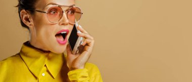 Stüdyoda bej arka planda izole edilmiş renkli sarı gömlek giyen beyaz iş kadınının yakın plan portresi.