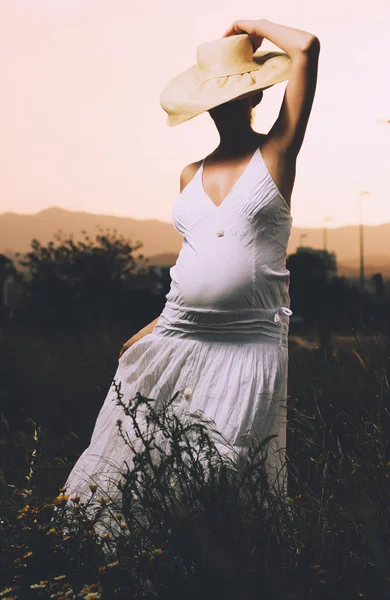 Mulher Grávida Vestindo Vestido Longo Branco Chapéu Posando Livre — Fotografia de Stock