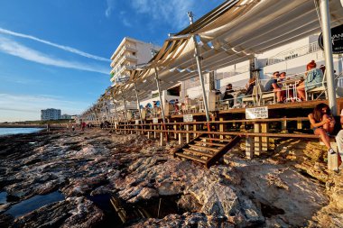 Ibiza Adası, İspanya - 1 Mayıs 2018: İnsanların kalabalıklar günbatımı Cafe Del Mar Sahil terrace adlı karşılamak. Gün batımı ve lounge müzik için görünümler için ünlü bir yer. Ibiza, Balear Adaları. İspanya