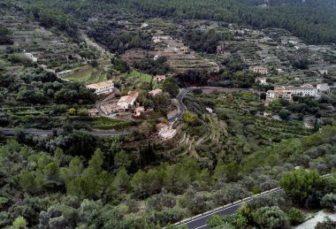 Mallorca'nın batı kıyısındaki küçük hillside Banyalbufar şehrin hava dron görünümü. Dağ bölgesi sokulur daha küçük tepeler arasında Tramuntana çevrili nerede çiftlikleri ve üzüm bağları dağınık. İspanya