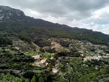 Mallorca'nın batı kıyısındaki küçük hillside Banyalbufar şehrin hava dron görünümü. Dağ bölgesi sokulur daha küçük tepeler arasında Tramuntana çevrili nerede çiftlikleri ve üzüm bağları dağınık. İspanya