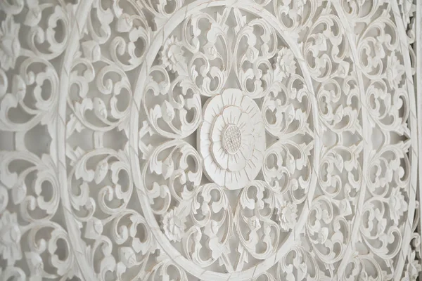 White wooden carved mural on a wall