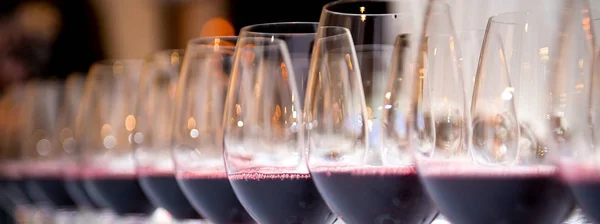 Verres de vin rouge en rangée sur une table — Photo